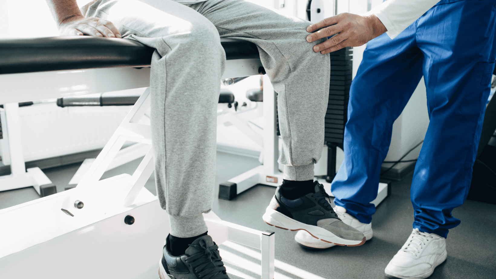 Man sitting down having knee attended to by medical professional