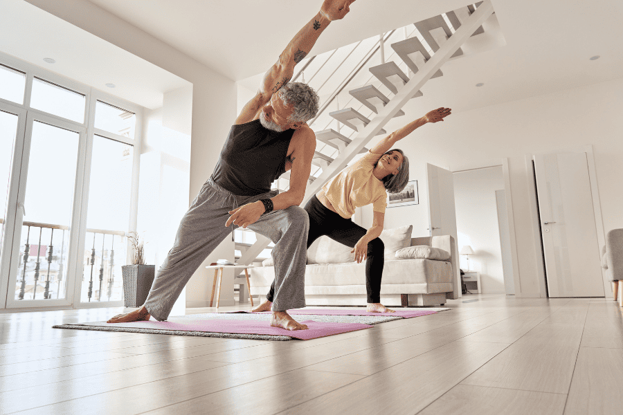 senior aged couple doing yoga stretches