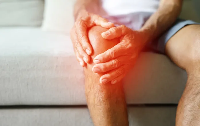 graphic of man holding knee with redness around hands